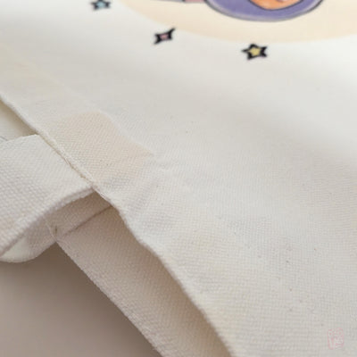 Close up of fabric for a cute kawaii wizard hamster tote bag with pastel fantasy artwork featuring a magical hamster holding a wand and spell book. Reusable 14 x 16 inch canvas polyester shoulder bag for shopping, school, and everyday use.
