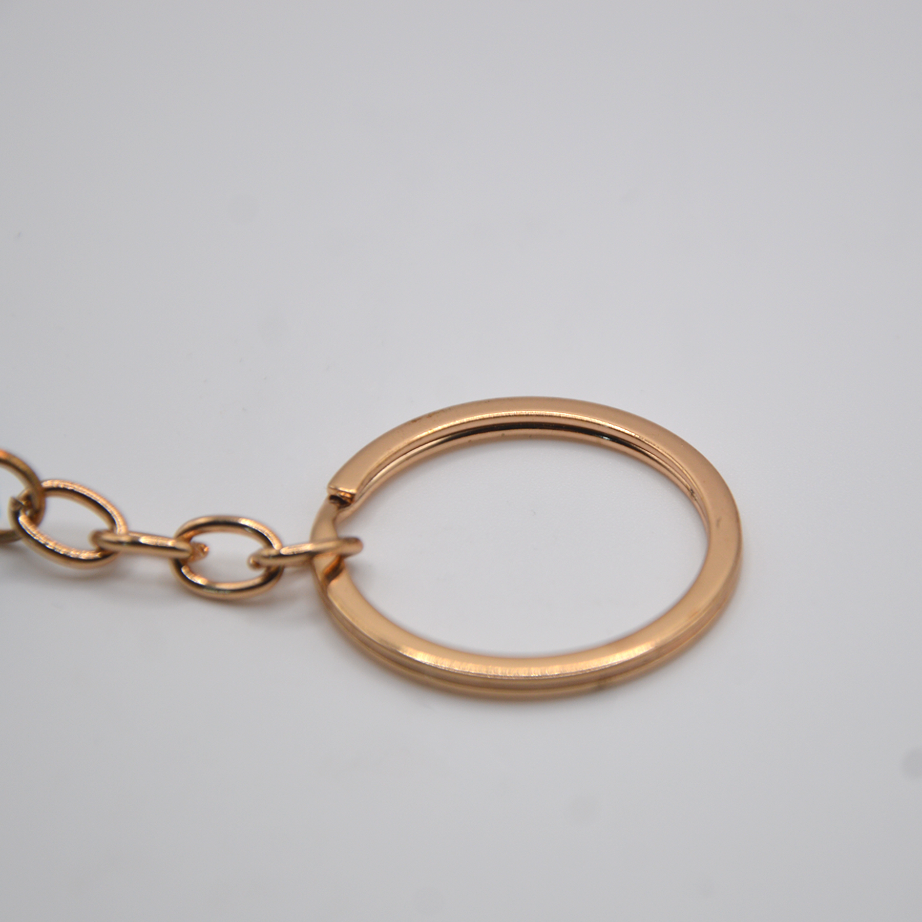 Rose gold keychain on a light gray background