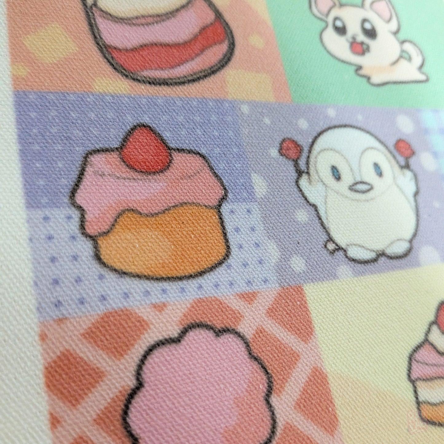 Close up shot 2 of cute pastel dessert-themed tote bag featuring original Radlab characters surrounded by cakes, macarons, ice cream, pastries, and café-inspired artwork. Reusable 14 x 16 inch canvas polyester tote bag for shopping, school, conventions, and everyday use.
